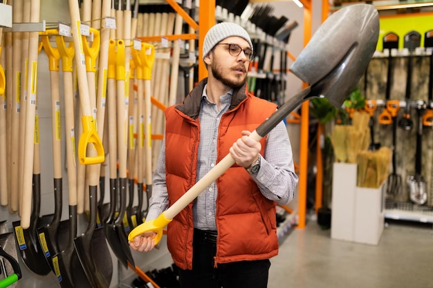 Lojas de materiais de construção um homem escolhe um novo martelo