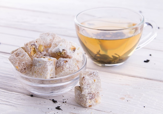 Lokum delicias turcas con té sobre fondo de madera