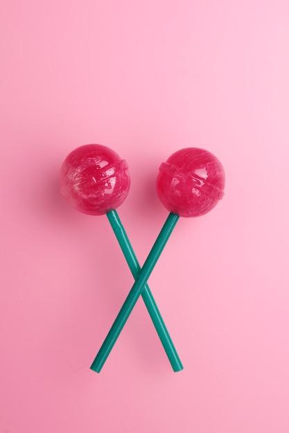 Lollipop colorido aislado. Concepto dulce de la piruleta en fondo rosado.