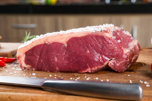 Lombo de bife cru vermelho orgânico na placa de madeira