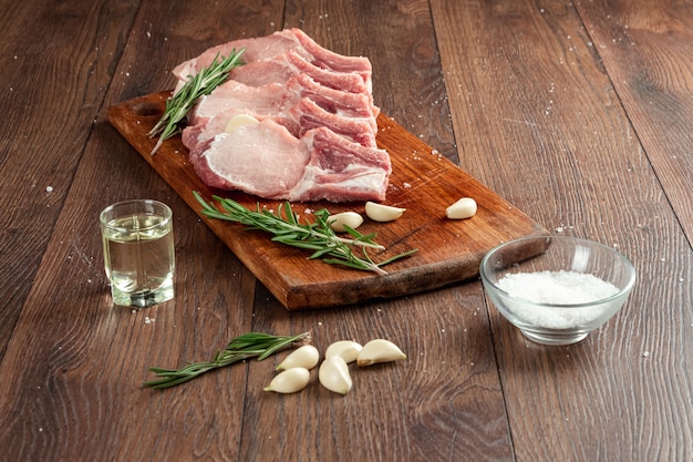 Lombo de bife fresco de carne crua e especiarias e uma faca encontra-se na madeira.