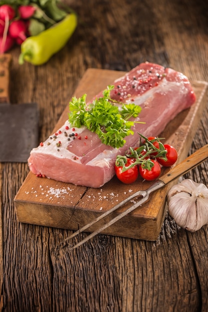 Lombo de porco filé salsa erva tomate pimenta alho sal e especiarias na placa de cozinha de madeira.