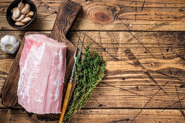 Lomo de cerdo crudo con especias sobre tabla de madera. fondo de madera. Vista superior. Copie el espacio.