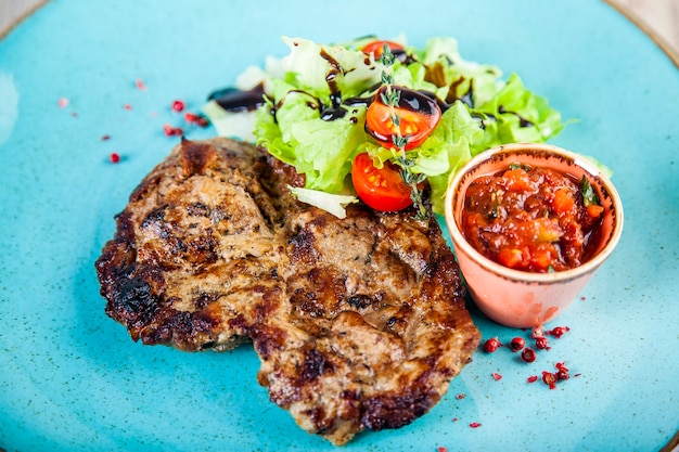 Lomo de cerdo con salsa picante de tomate y ensalada