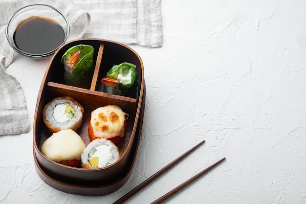 Lonchera bento japonesa con palillos, sobre fondo de piedra blanca, con espacio de copia y espacio para texto