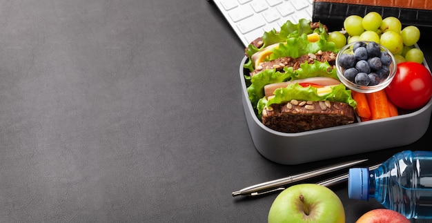 Lonchera de oficina saludable con sándwich y verduras frescas