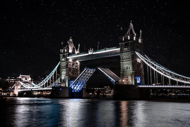 London Tower Bridge levantando por la noche. Luces nocturnas que iluminan el famoso puente de la Torre de Londres.