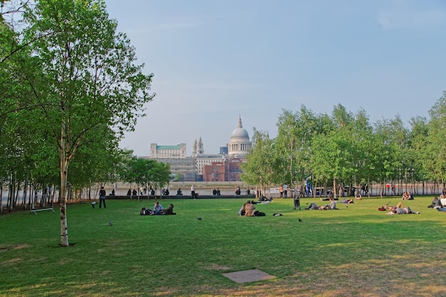 Londres, Inglaterra - 29 de abril de 2011: Gente relajándose en un pequeño parque en Bankside con vistas a la Catedral de San Pablo en Londres en Inglaterra. Es una catedral anglicana diseñada por Sir Christopher Wren.