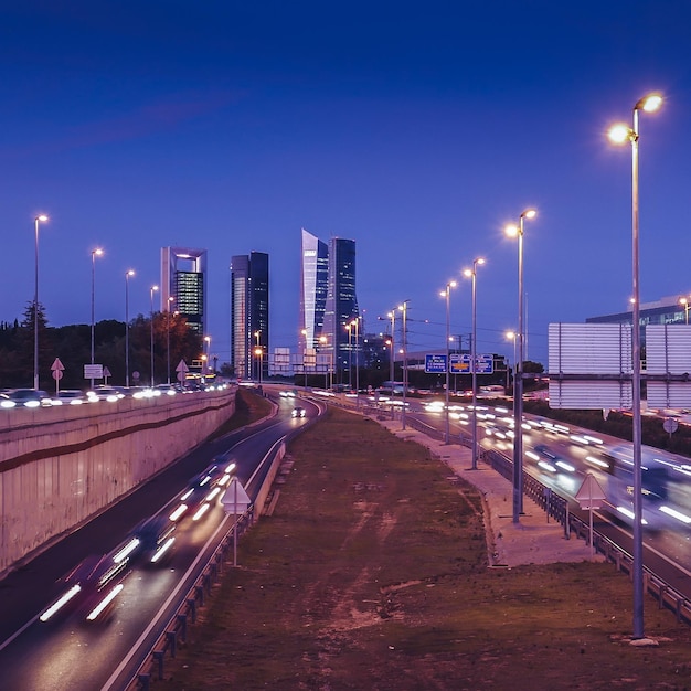 Longa exposição de tráfego rodoviário pesado, olhando para o distrito de negócios de Cuatro Torres em Madrid Espanha