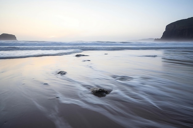 Longa exposição de uma praia ao pôr do sol com areia e pedras em primeiro plano