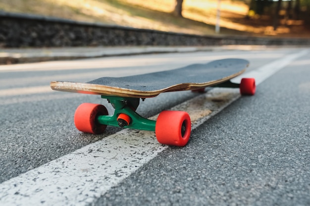 Longboard mit roten Rädern auf dem Asphalt. Hochwertiges Foto