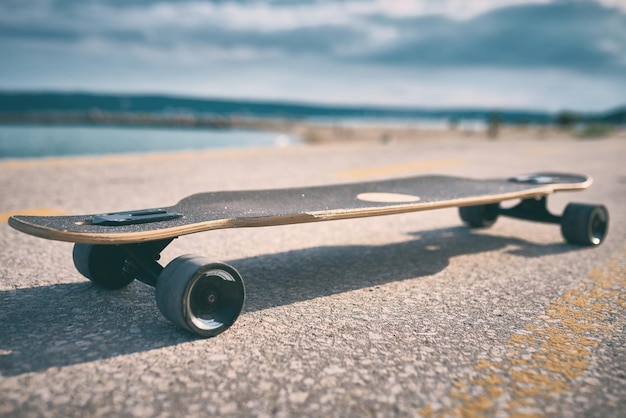 Longboard no asfalto na perspectiva do mar sem pessoas