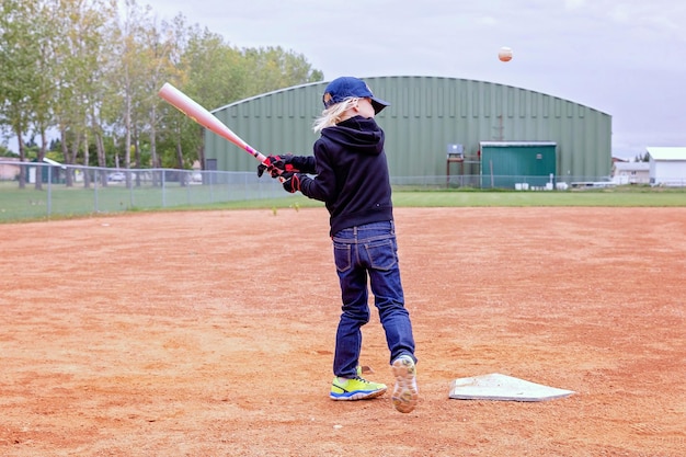 Foto la longitud completa de la chica jugando al béisbol en el campo