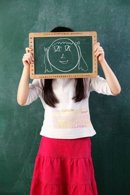 Foto la longitud completa de una chica de pie contra la pared