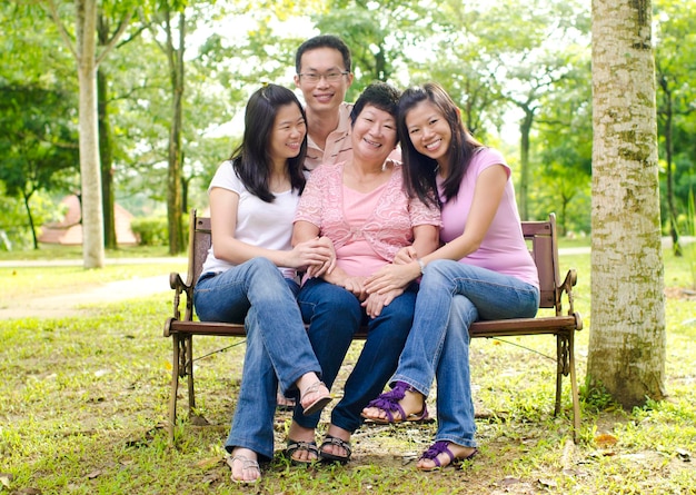 Foto la longitud completa de la familia sonriente en el parque