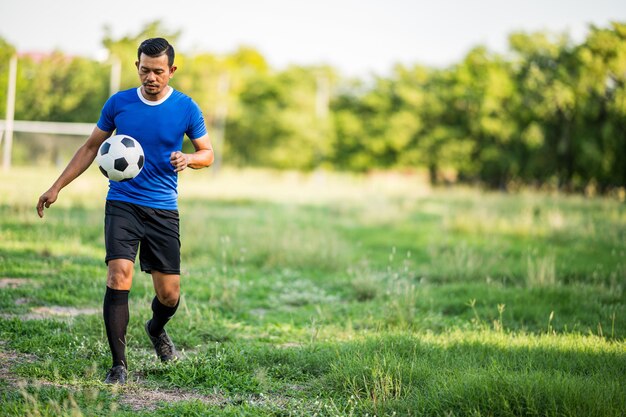 La longitud completa del hombre corriendo en el campo