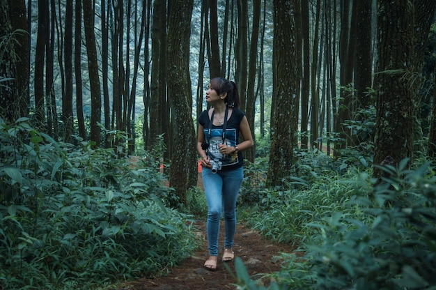 Foto la longitud completa de la mujer asiática caminando en el bosque