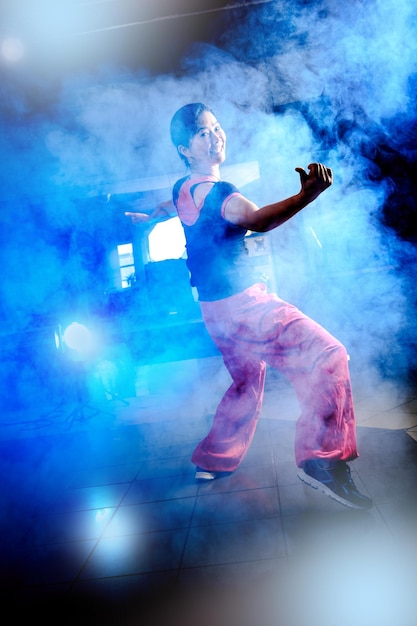 La longitud completa de la mujer bailando en medio del humo