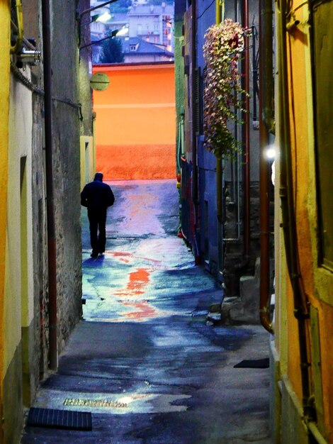 Foto la longitud completa de la mujer caminando por el callejón