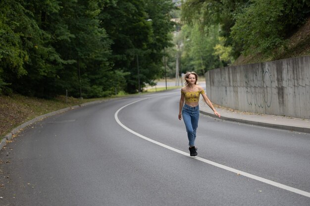 Foto la longitud completa de la mujer caminando por la carretera