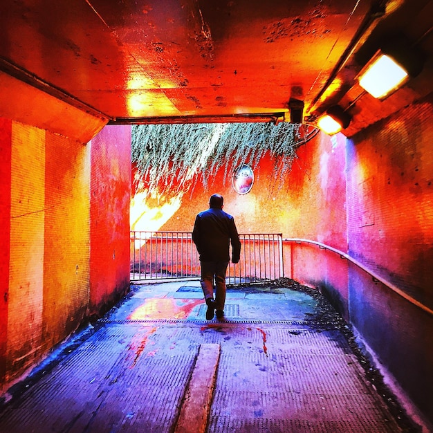 Foto la longitud completa de la mujer caminando en el túnel