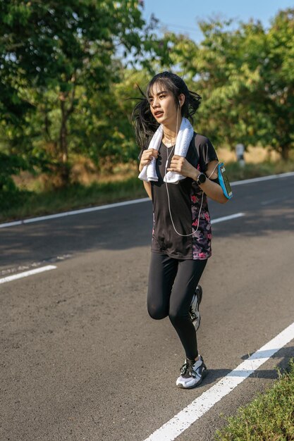 Foto la longitud completa de la mujer en el camino contra los árboles