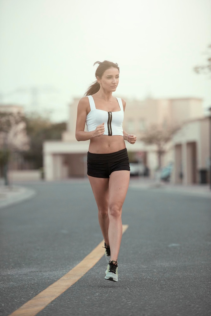 Foto la longitud completa de la mujer corriendo por la carretera