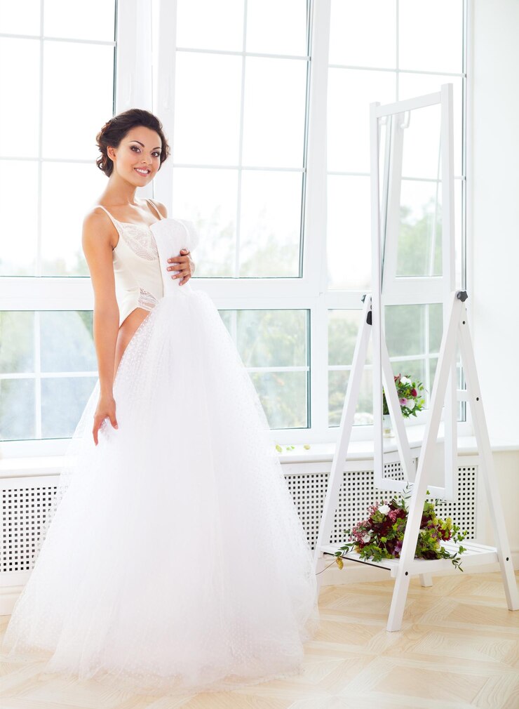 Foto la longitud completa de la mujer feliz de pie contra la ventana