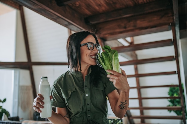 Foto la longitud completa de una mujer joven bebiendo un vaso