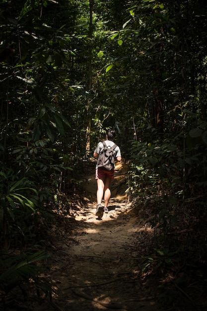 Foto longitud completa de una mujer joven caminando en el bosque