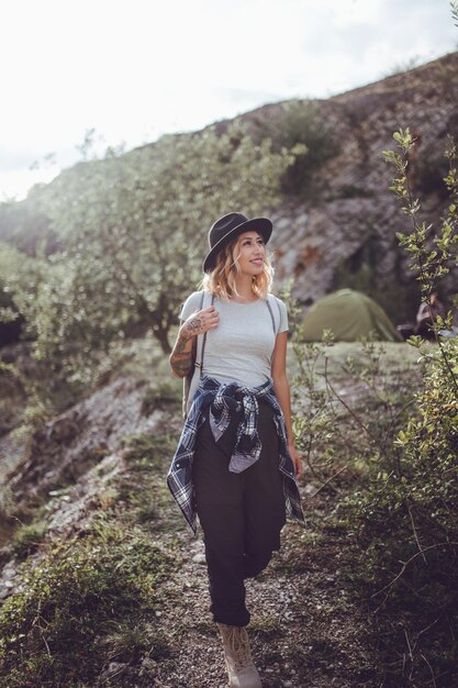 Foto la longitud completa de una mujer joven caminando por la montaña