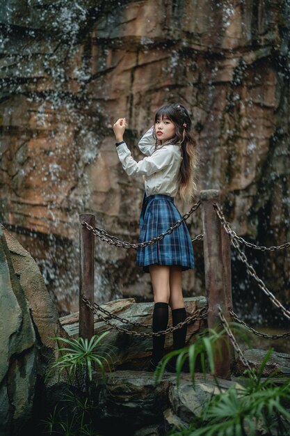 Foto la longitud completa de una mujer joven de pie en el bosque