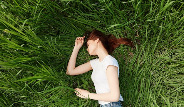 Foto la longitud completa de una mujer joven sentada en un campo de hierba