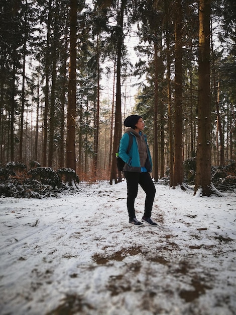 Foto la longitud completa de la mujer de pie en el bosque congelado