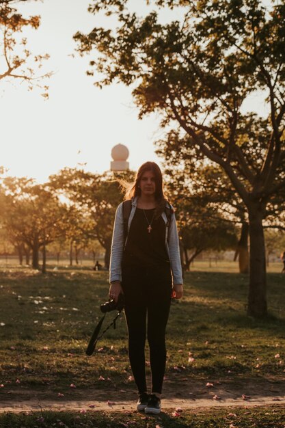 Foto la longitud completa de la mujer de pie en el campo contra los árboles