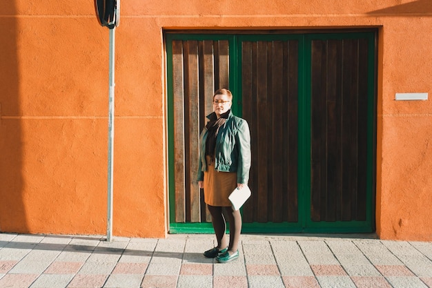 Foto la longitud completa de la mujer de pie contra la puerta cerrada en un día soleado