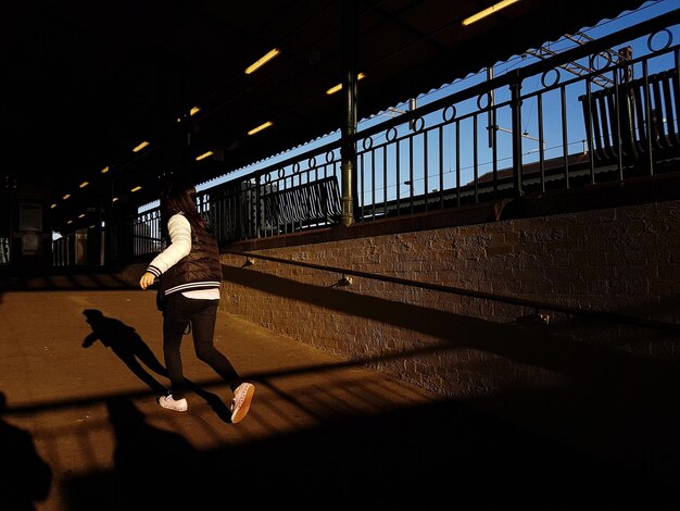 Foto la longitud completa de la mujer en el puente iluminado contra el cielo en la ciudad