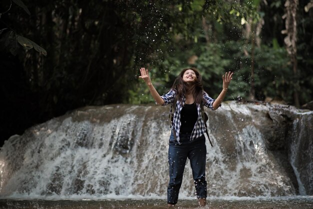 Foto la longitud completa de la mujer salpicando agua en el bosque