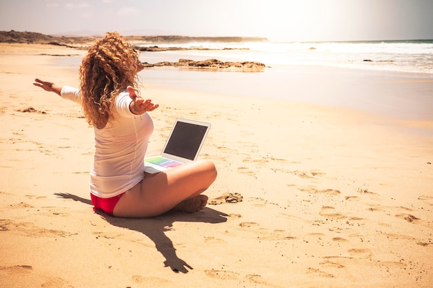 Foto la longitud completa de la mujer sentada en la playa