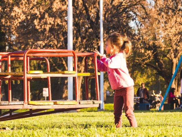 La longitud completa de la niña jugando en el parque de juegos