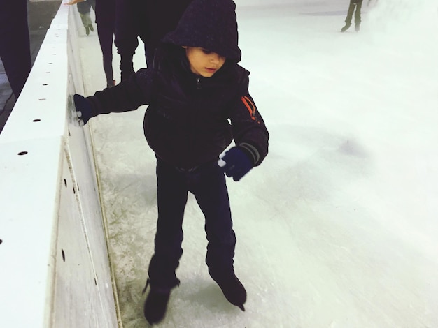 Foto la longitud completa del niño en la nieve