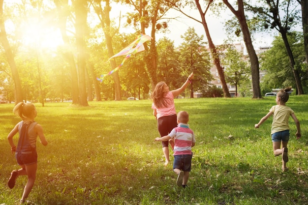 Foto la longitud completa de los niños corriendo mientras vuelan cometa en el campo