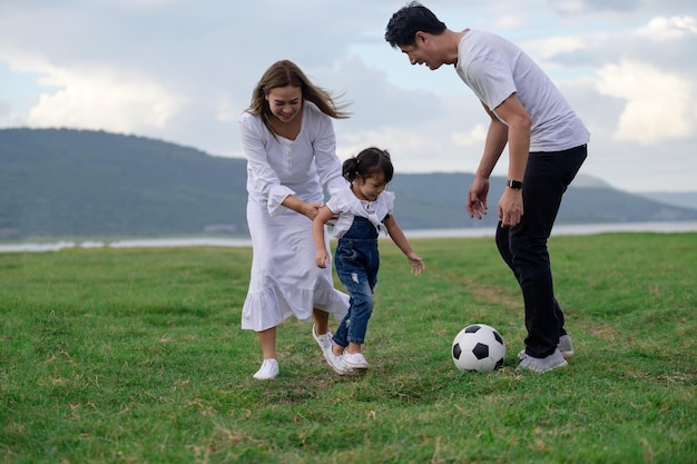 Foto la longitud completa del padre con la pelota en el césped