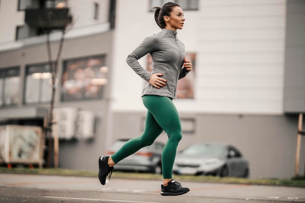 Longitud total de una deportista en forma corriendo en la calle del centro