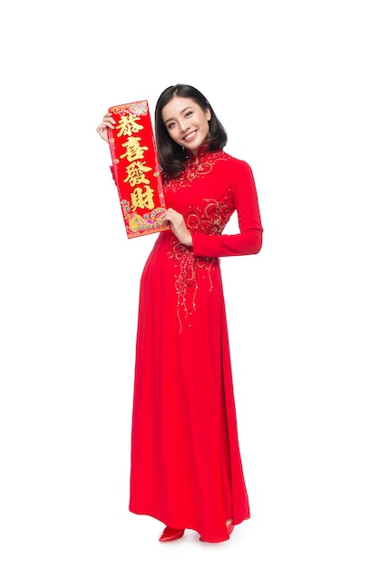 Longitud total de una hermosa mujer asiática en traje de fiesta tradicional Ao Dai. Tet vacaciones. Año Nuevo Lunar. El texto significa suerte y felicidad.