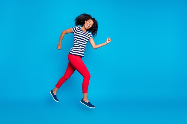 Longitud total de mujer afroamericana loca alegre saltar correr rápido