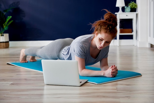 Foto la longitud total de la mujer haciendo ejercicio en casa