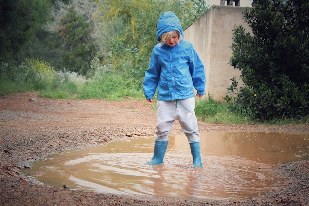 La longitud total del niño de pie en el charco