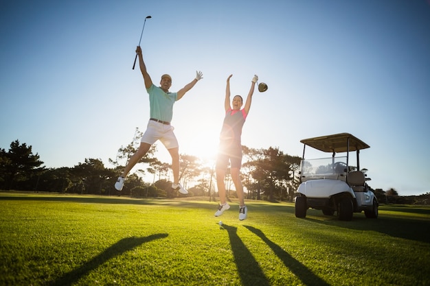 Longitud total de pareja de jugador de golf con los brazos levantados