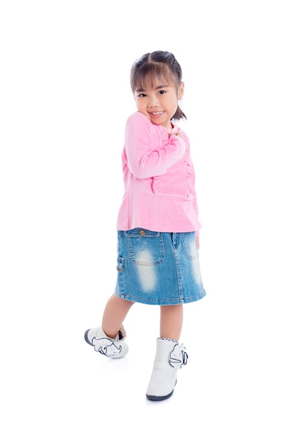 Longitud total de una pequeña niña asiática de pie sobre fondo blanco